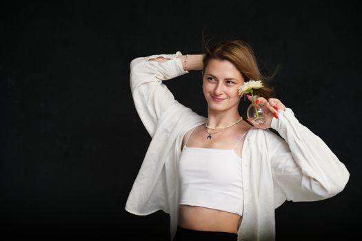 portrait with flower cute young caucasian smiling girl on black background in studio