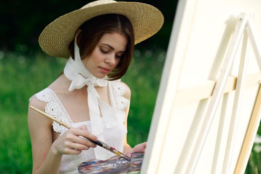 woman artist draws a picture on an easel outdoors. High quality photo