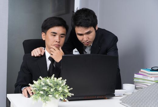 two business man using a laptop and discussing project