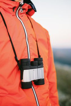 Unrecognizable hiker walking with binoculars outdoor.