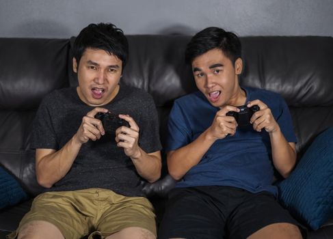 two happy man playing video games at night