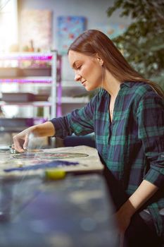 Confident female florist is working with dryed flowers in cozy flower shop