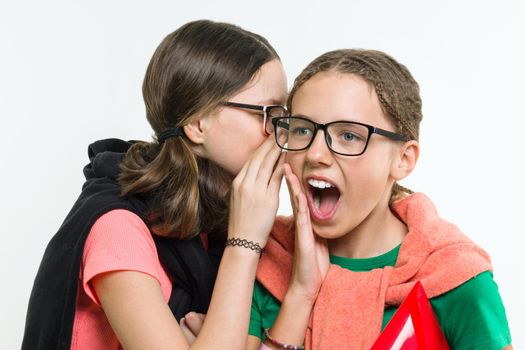 Portrait of two 12-13 year old girls. Beautiful teenage girlfriends communicate, secrete and smiling