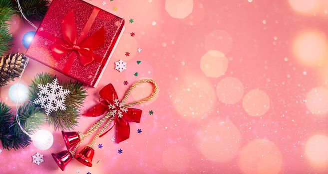 Christmas pink background with gift boxes, decorations and fir branches