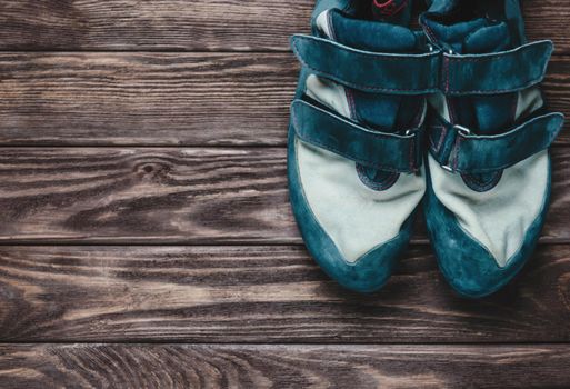 Shoes for rock climbing sport on a wooden background. Copy-space.