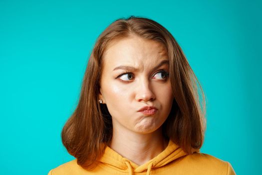 Studio portrait of beautiful young casual woman thinking about something