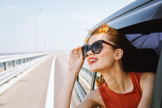 pretty woman in sunglasses rides in a travel car. High quality photo