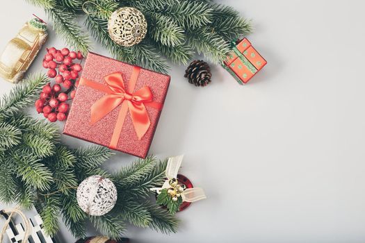 Frame of twigs christmas tree, brown natural pine cones and red berries on snow with space for text. Top view, flat lay