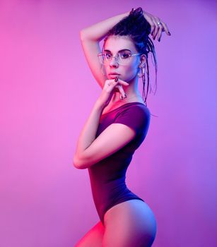 the slender girl on a white background of neon color posing in a bodysuit