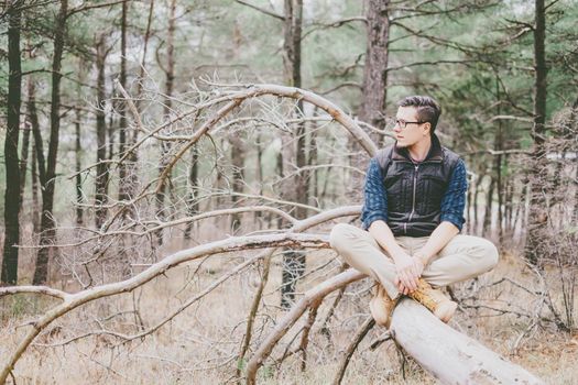 Explorer young man rests in the woods.