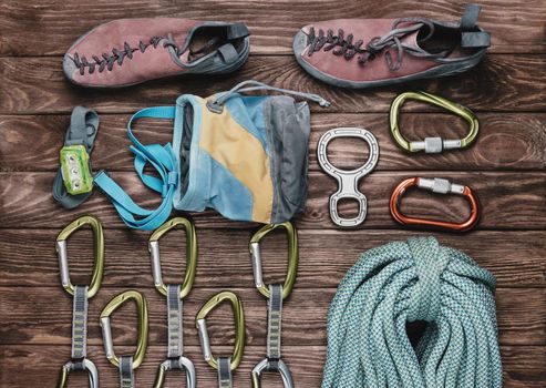 Equipment for climbing sport on wooden background, top view.