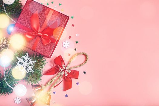 Christmas pink background with gift boxes, decorations and fir branches