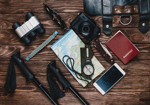 Tourism objects on wooden background, top view.