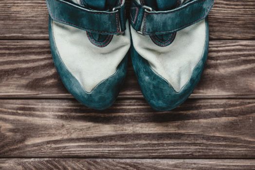 Climbing shoes on wooden background.