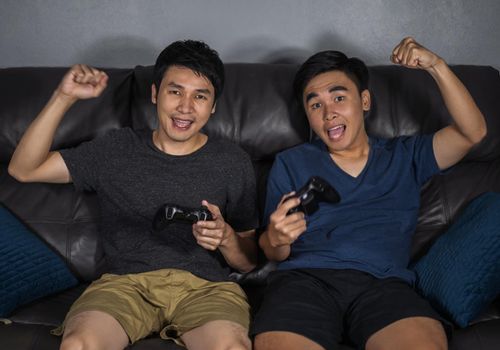 two young man playing video games and wins 