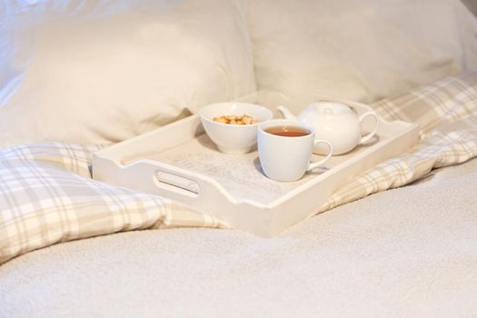 morning breakfast with cookies at bed- striped teaset on breakfast tray in white bedroom