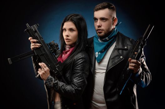 the girl and a guy in a leather jacket with a gun