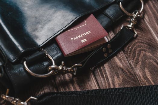 Bag with passport on a wooden background, concept of travel.