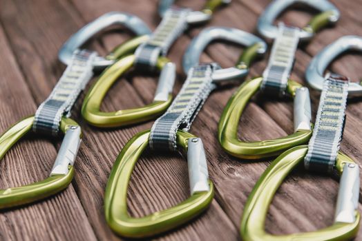 Quickdraws for climbing sport on a wooden background.