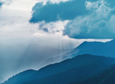 Mist over blue mountains in cloudy weather.