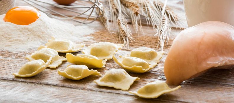 Ravioli and chicken breast on a flour board