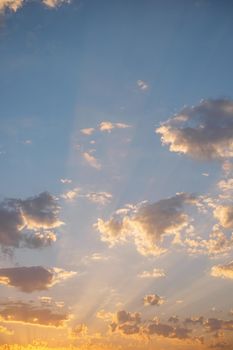 Sky background, beautiful sunset with sunbeams among clouds.