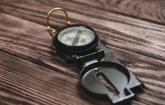 Hiking compass on a wooden background.