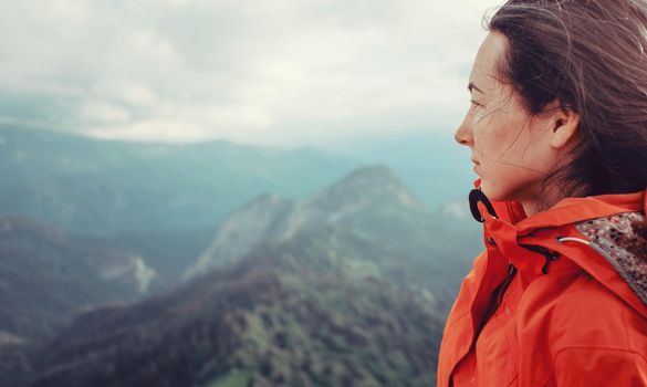 Portrait of hiker young woman on background of summer mountains.