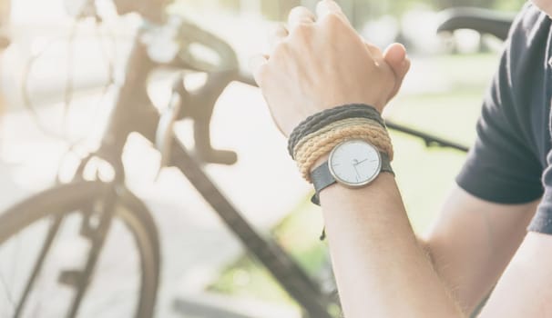 Unrecognizable man with bicycle, view of hand with watch.