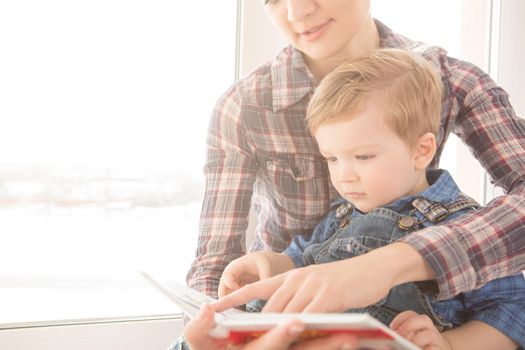 Mother reading to her child an interesting story. The concept of happiness and love.