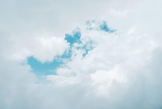 Background of white cloud with piece of blue sky in the centre.