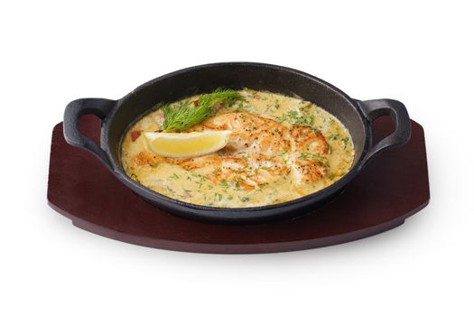 Fish fillet cooked in cream sauce isolated on white background