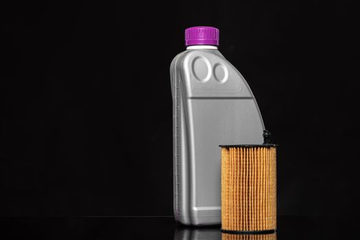Car oil filters and motor oil can on dark background, close up.