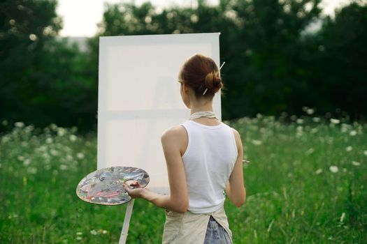 woman artist outdoors easel drawing creative landscape. High quality photo