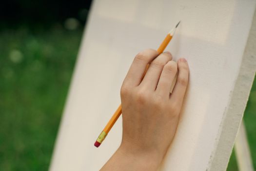 female hand with pencil easel drawing close up. High quality photo