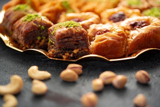 Delicious baklava dessert in oriental setting on black background, close up