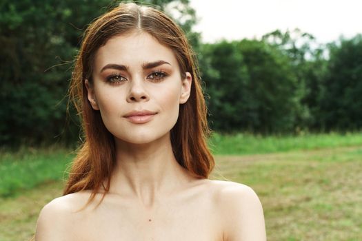 beautiful woman in a field outdoors bare shoulders clear skin cropped view. High quality photo