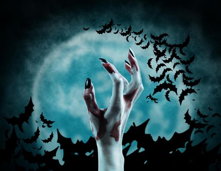 Hand of vampire on background of full moon