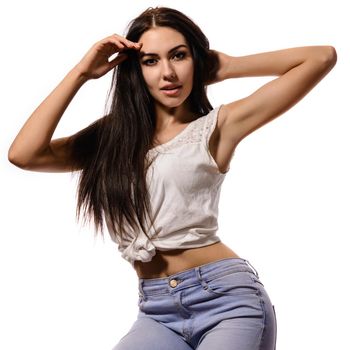 Young positive brunette girl with long hair wearing t-shirt and jeans on white background