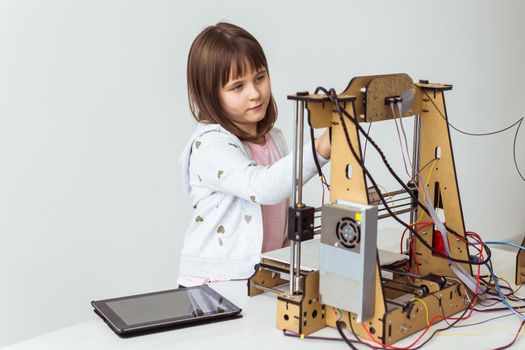 Child student makes the item on the 3D printer. School, technologies and science.