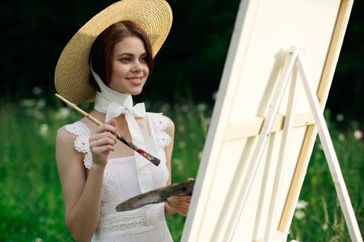 Woman in white dress artist easel painting nature landscape. High quality photo