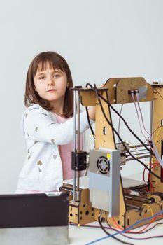 Cute girl with 3d printed shutter shades is watching her 3d printer as it prints her 3d model