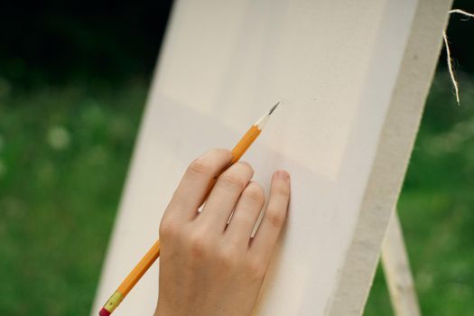 female hand with pencil easel drawing close up. High quality photo