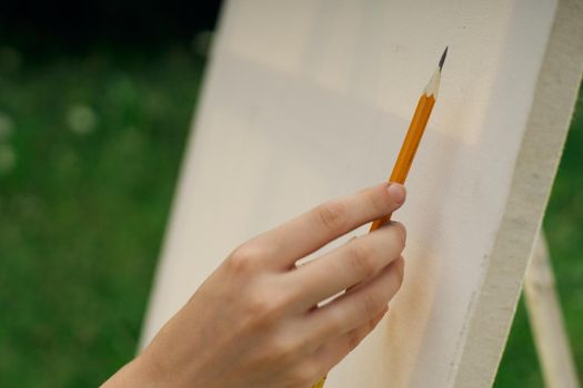 female hand with pencil easel drawing close up. High quality photo