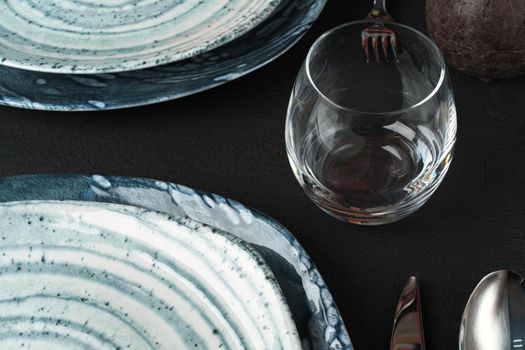 Table setting. Plates with abstract pattern on black table. High quality photo