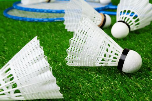 Badminton game rackets and shuttlecock on grass. Close up.