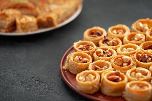 Delicious baklava dessert in oriental setting on black background, close up