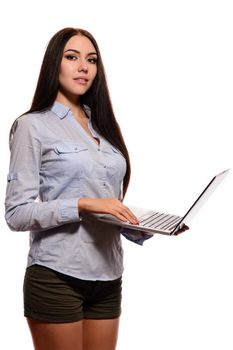 A smiling Oriental girl in a denim shirt was opened laptop on a white background