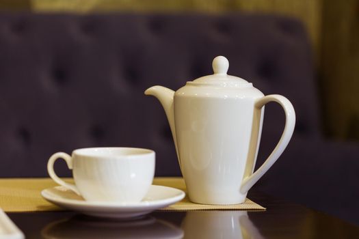 Tea cup and tea pot on table. Breakfast and Five O'Clock Tea.