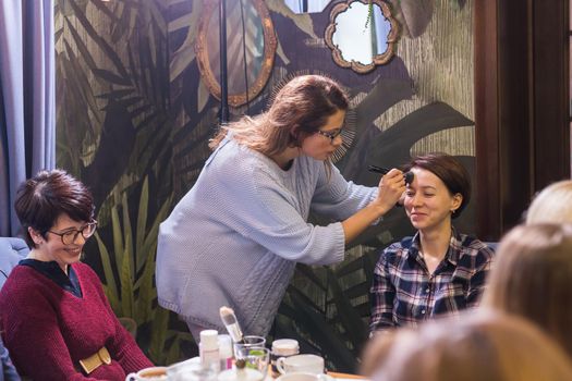 Professional make-up artist conducts a master class to improve the skills of a beginner make-up artists. Beauty and business.